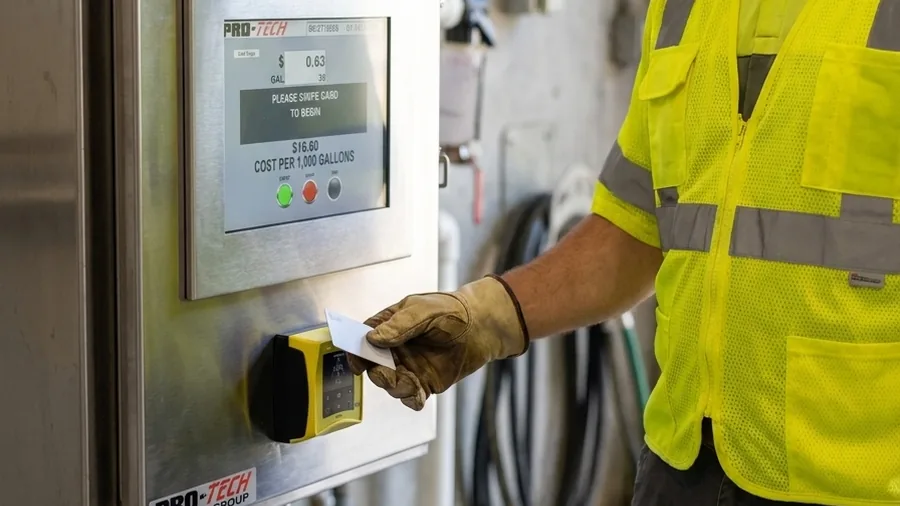 Worker tapping an RFID card at a cashless bulk water station control panel